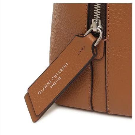 Close-up tas kulit coklat GIANNI CHIARINI. Ini memiliki ritsleting logam dan label kulit yang bertuliskan "GIANNI CHIARINI FIRENZE" berwarna putih. Itu dibuat di Italia dan memancarkan keanggunan Italia yang tak lekang oleh waktu.